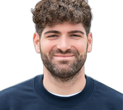 Freundlich lächelnder Mann mit kurzen, lockigen dunklen Haaren und Bart, der einen dunkelblauen Pullover mit Reißverschluss trägt.