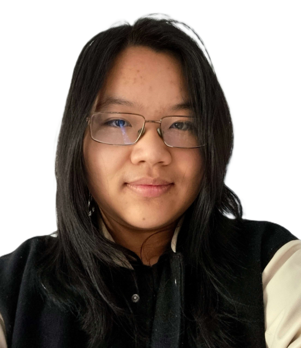 Portrait einer jungen Person mit schulterlangen, dunklen Haaren und Brille. Sie schaut freundlich in die Kamera und trägt eine dunkle Jacke über einem hellen Oberteil. Der Hintergrund ist vollständig schwarz.