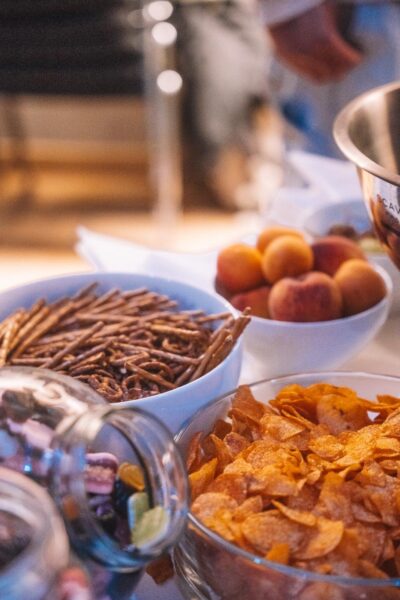 Mehrere Glasbehälter mit bunten Süßigkeiten, darunter Herzen und andere Formen. Eine Zange liegt in einem der Gläser.