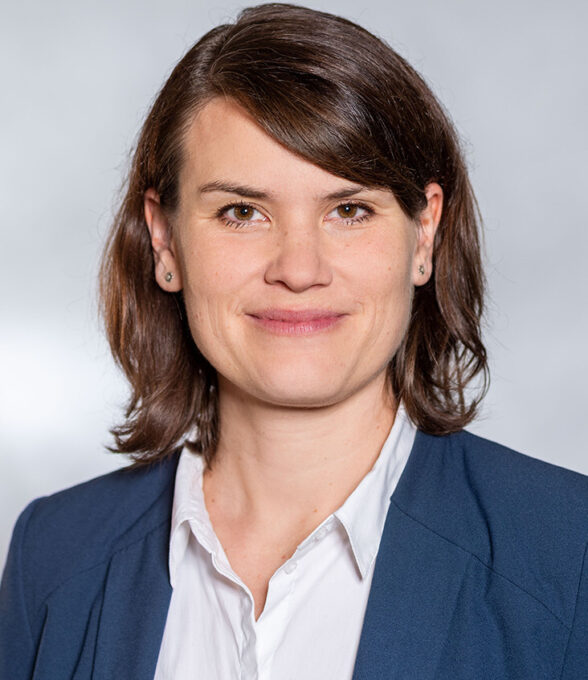 Miriam Goetz hat kurze fast schulterlange braune Haare und trägt einen blauen Anzug.