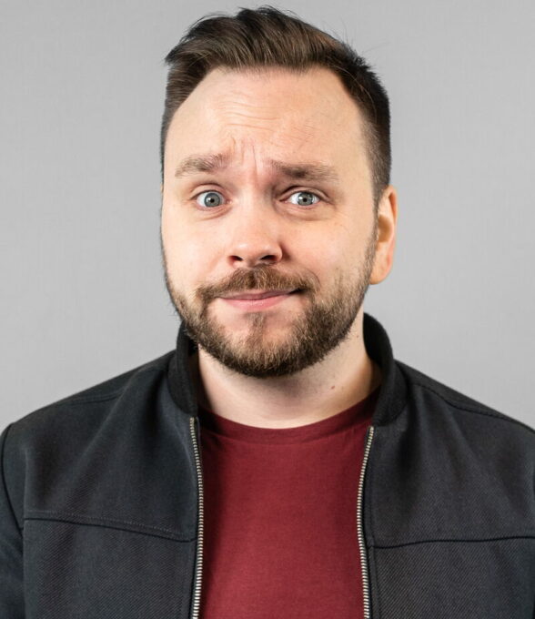 Ren Kühn, Moderator, schaut mit einem schelmischen Lächeln und hochgezogener Augenbraue in die Kamera.